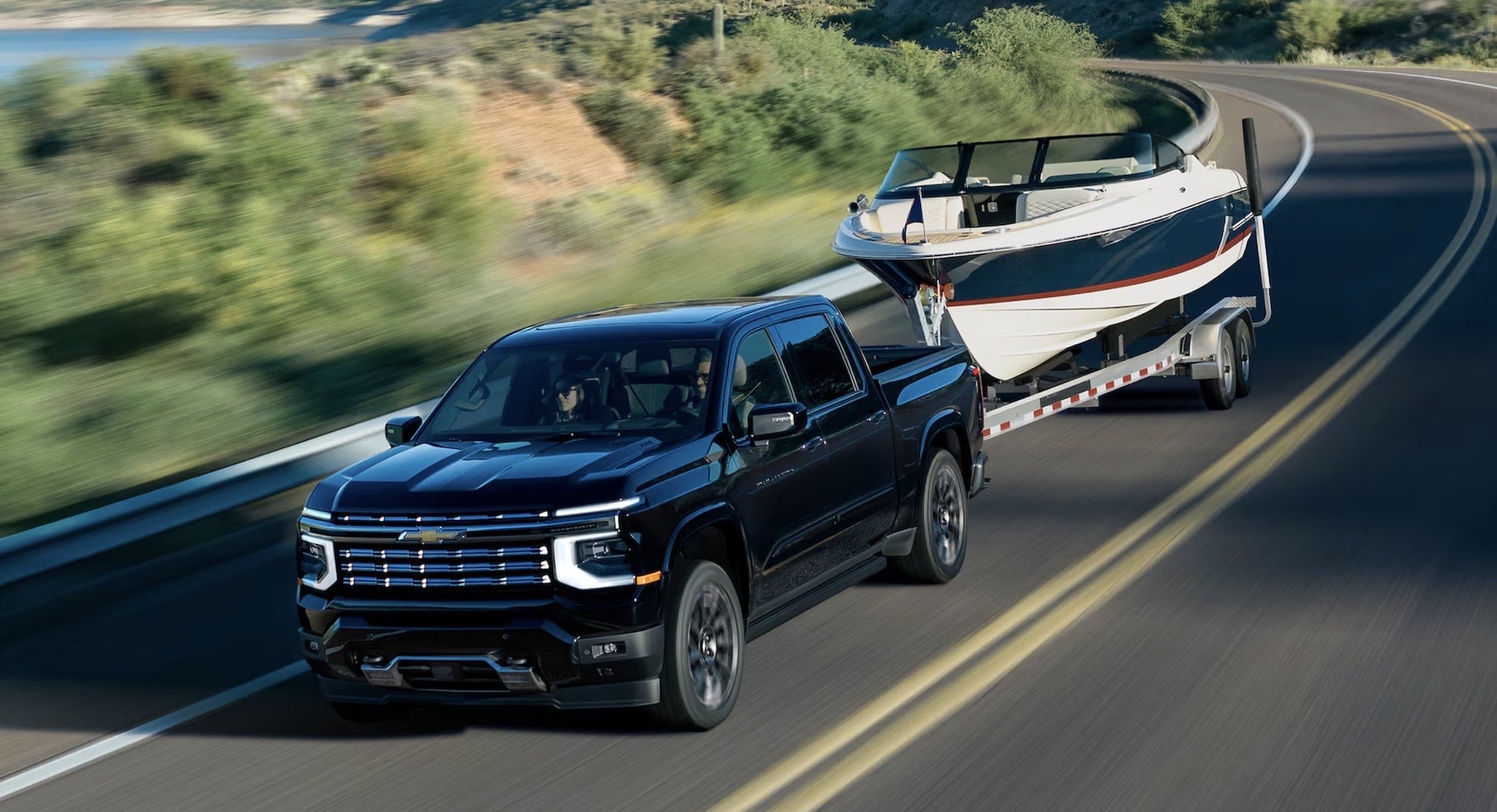 2027 Chevrolet Silverado 1500 in Black towing a boat trailer