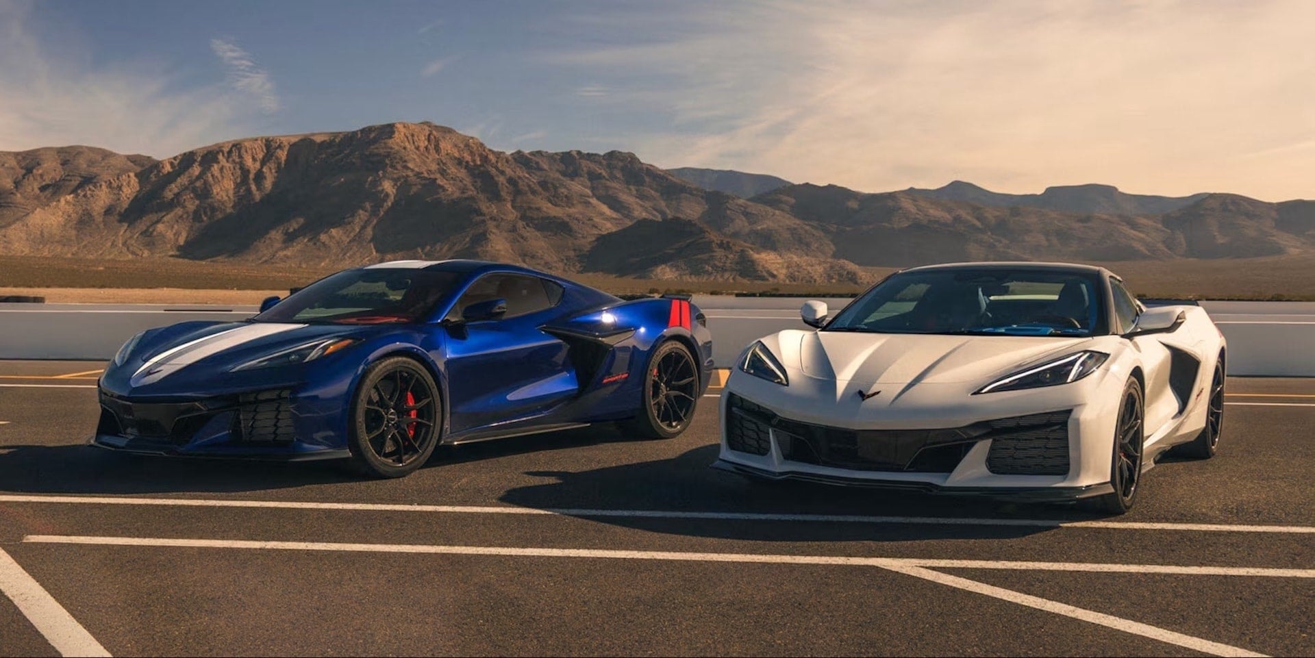 Two 2027 Chevrolet Corvette Grand Sport models in blue and white, side by side, front view